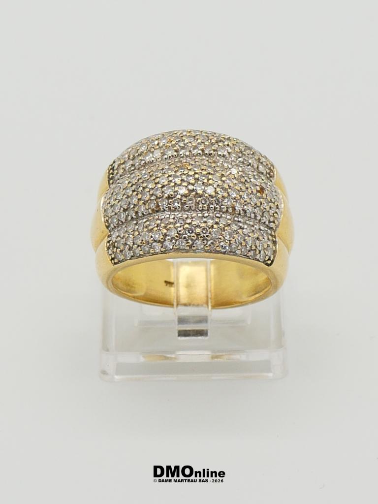Gold band ring with pavé diamonds on the top, displayed on a clear stand.