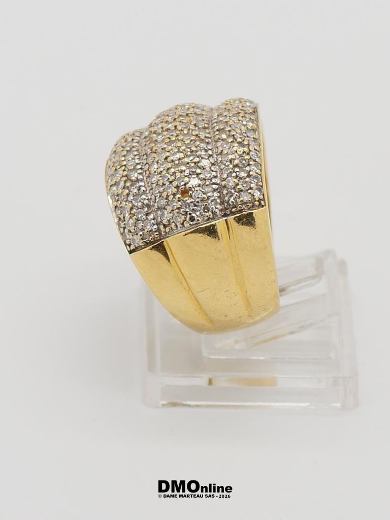 Gold ring with a diamond-paved top, displayed on a clear acrylic stand.