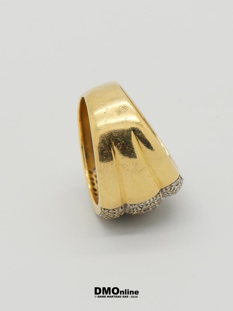 Gold ring with a domed band and a diamond-dotted bottom edge.