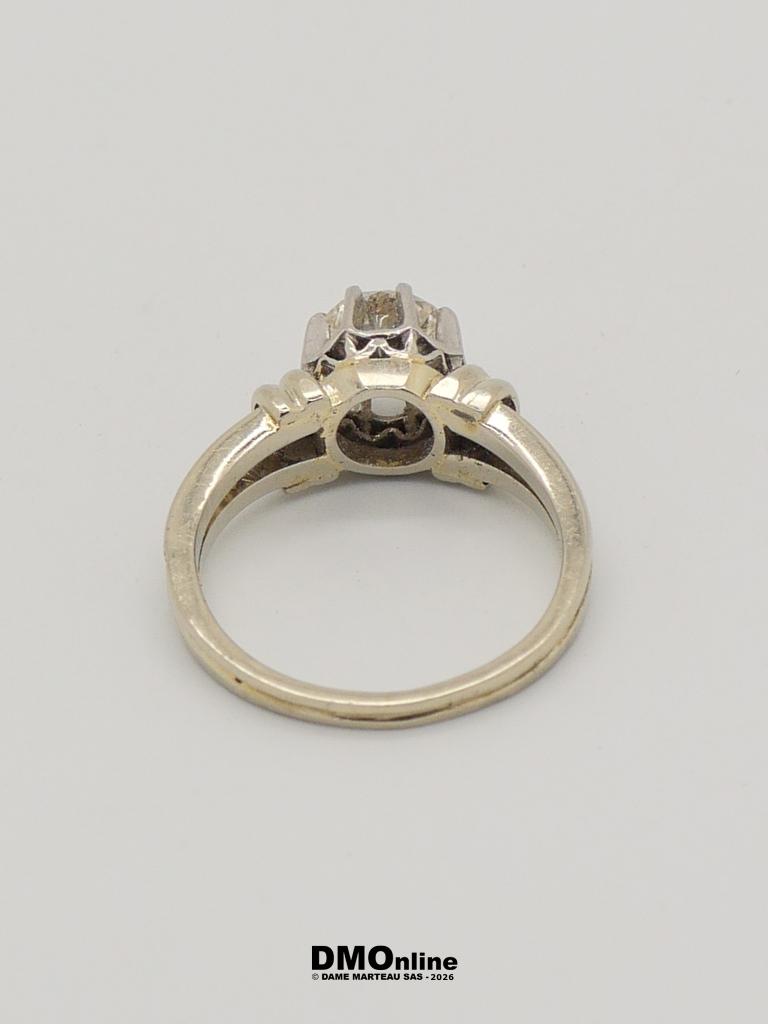 Silver ring shown from the side/bottom, with a raised prong setting ready for a gemstone and a smooth band beneath.