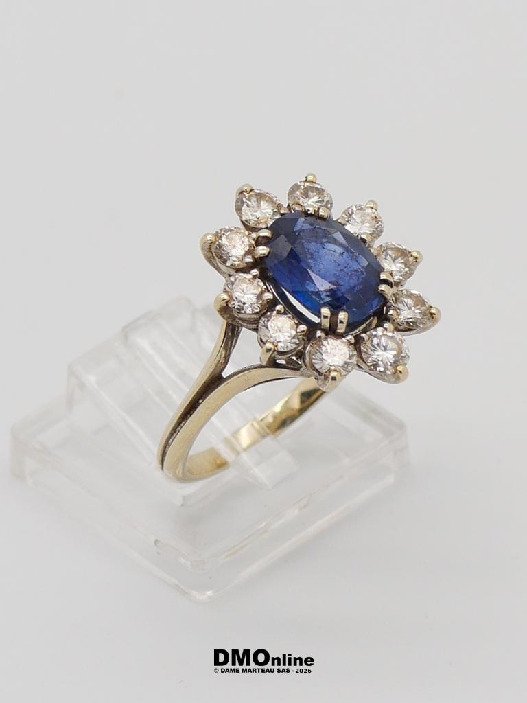 Gold ring with an oval blue sapphire surrounded by a halo of diamonds in a flower setting