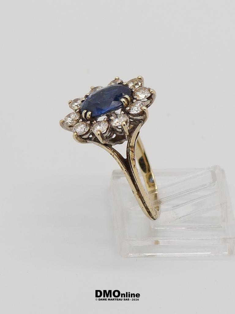 Yellow-gold ring with a deep-blue sapphire center stone surrounded by a diamond halo.