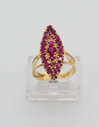 Gold ring featuring a leaf-shaped cluster of pink gemstones on a clear display stand.