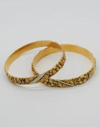 Two gold bracelets with embossed floral patterns, intertwined on a white background, showing a silver diagonal accent.